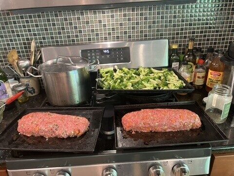 Two shaped meatloaves with broccoli and potatoes staged for a group dinner